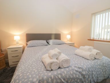 A bedroom with a bed and towels arranged at Mables in Wigton