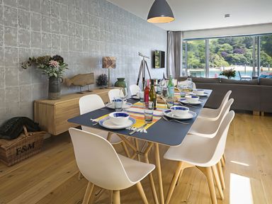 A dining room set with a table, chairs, and decorative items at Villa 8, Estura Salcombe