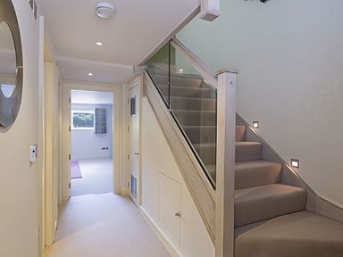 A hallway with a staircase and a door at Villa 8, Estura Salcombe