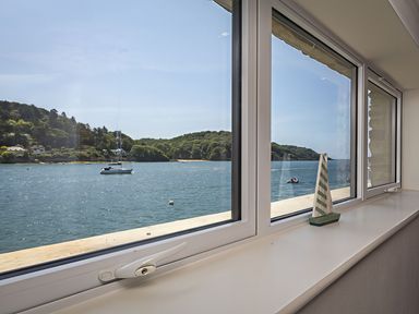 A view of the water and a sailboat from a window at Villa 8, Estura in Salcombe