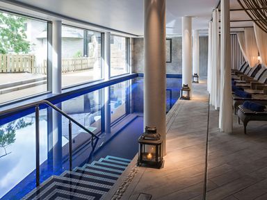 An indoor pool area with seating and windows at Villa 8, Estura in Salcombe