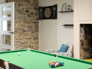 A game room with a pool table and dartboard at 6 Front Street