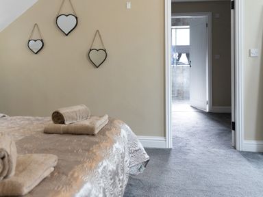 A bedroom with towels on the bed and a doorway leading to another room at 6 Front Street