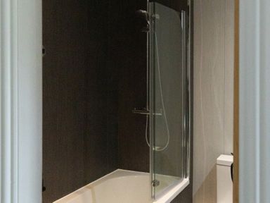 A bathtub with a shower and a toilet at 6 Front Street 