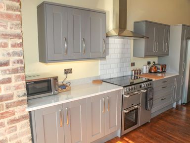 A kitchen with cabinets and appliances at The Granary in Durham