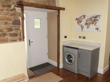A laundry room with a washing machine and countertop at The Granary in Durham