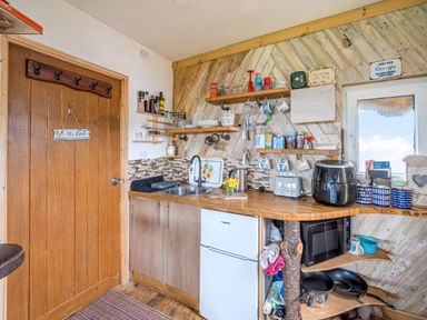 A kitchen with a sink and various kitchen appliances at The Retreat Cabin in Llanelli