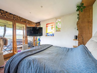 A bedroom with a bed and television at The Retreat Cabin in Llanelli