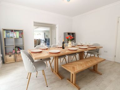 A dining room with a wooden table and striped chairs at Cootiya Corner in Great Lyth