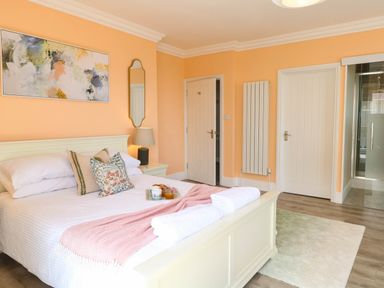 A bedroom with a bed, bedside table, and a mirror at Cootiya Corner in Great Lyth