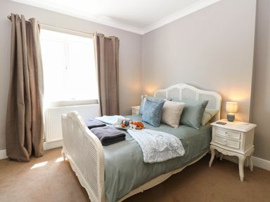 A bedroom with a bed, nightstand, and window at Cootiya Corner in Great Lyth