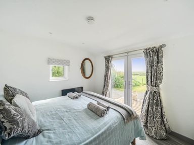 A bedroom with a bed and a window at The lodge at Plumstone View Letterston