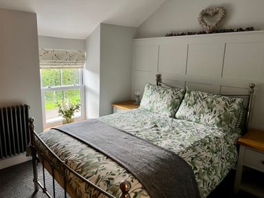 A bedroom with a bed and window at Penderyn Cottage in Aberdare