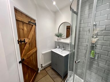 A bathroom with a shower and sink at Penderyn Cottage Aberdare