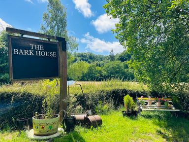 A garden with a sign for The Bark House in Tiverton