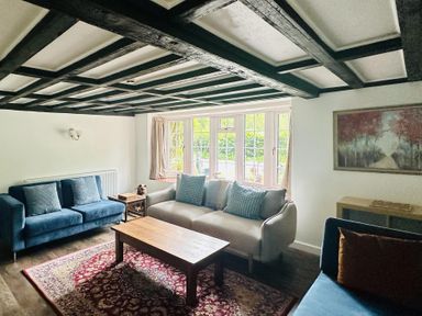 A living room with sofas and a wooden table at The Bark House in Tiverton