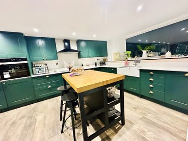A kitchen with cabinets and an island at The Bark House in Tiverton