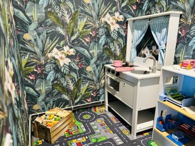 A playroom with a toy kitchen and blocks at The Bark House in Tiverton