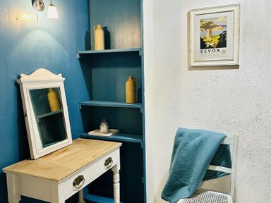 A room with a desk, mirror, shelves, and chair at The Bark House in Tiverton