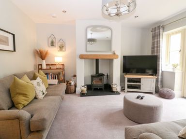 A living room with a fireplace and television at East View in Cheltenham