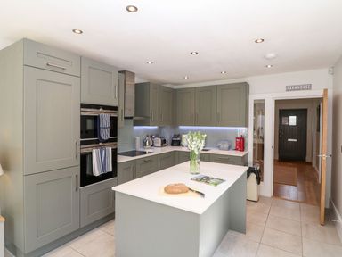 A kitchen with cabinets, oven, and kitchen island at East View Cheltenham