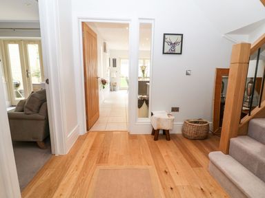 A hallway with stairs and a sofa at East View in Cheltenham