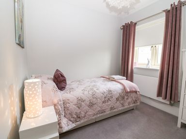 A bedroom with a bed and lamp at East View in Cheltenham