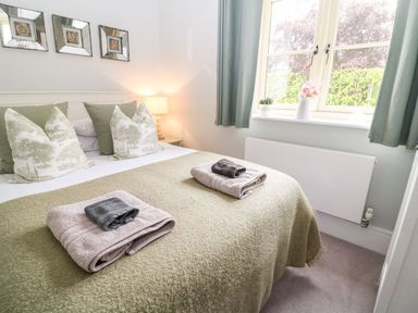 A bedroom with a bed and towels at East View in Cheltenham