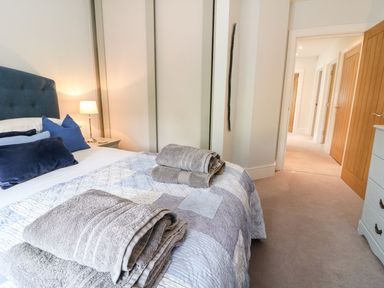 A bedroom with a bed and towels at East View in Cheltenham