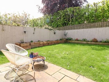 A garden with raised flower beds and a chair at East View in Cheltenham