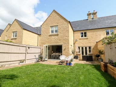 A garden with a house and patio furniture at East View in Cheltenham