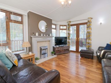 A living room with a sofa and television at 6 Waterside in Windermere