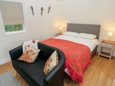A bedroom with a bed and sofa at Heidiaway Lodge in Gilfach Goch