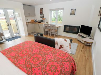 A living room with a kitchenette, dining table and sofa at Heidiaway Lodge in Gilfach Goch