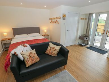 A bedroom with a bed and a sofa at Heidiaway Lodge in Gilfach Goch