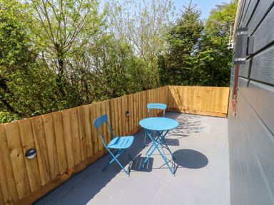 A balcony with a blue table and chairs at Heidiaway Lodge in Gilfach Goch