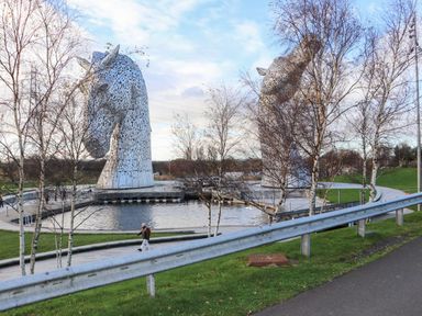 Two large horse sculptures beside a water feature at Beechtree Timber Lodge 69B in Denny