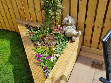 A triangular flower bed with a statue and plants in a garden at 226 Third Avenue in Bridlington