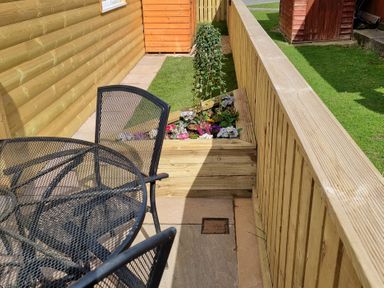 A seating area with a table and chairs beside a flower bed at 226 Third Avenue in Bridlington