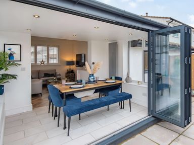 A dining room with a table and chairs at 6 Tegafan Abergele