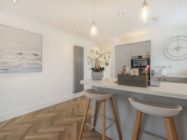 A kitchen with a kitchen island and bar stools at 6 Tegafan Abergele