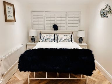 A bedroom with a bed, nightstands and lamps at 6 Tegafan in Abergele