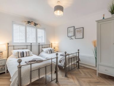 A bedroom with two beds and a wardrobe at 6 Tegafan in Abergele