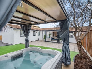An outdoor area with a hot tub and patio at 6 Tegafan in Abergele