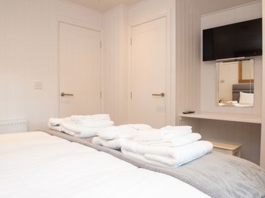A bedroom with towels on a bed at Nethermill Lodges in Port Glasgow