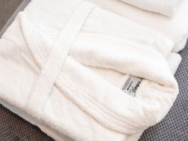 A folded bathrobe and towel at Nethermill Lodges in Port Glasgow