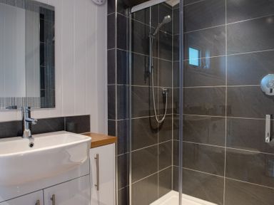 A bathroom with a sink and shower at Nethermill Lodges Port Glasgow