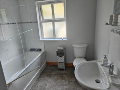 A bathroom with a bathtub, toilet, and sink at 17 Castleview in Ballymena