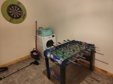 A utility room with a foosball table and a washing machine at 17 Castleview in Ballymena