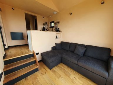 A living room with a sofa and stairs at Cullinview in Isle of Skye